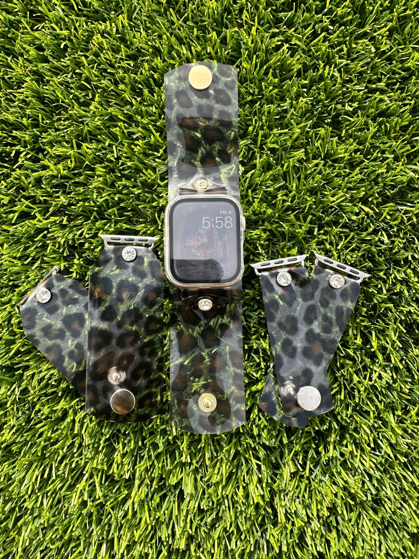 A transparent PVC waterproof band perfect for all year round. It's great to wear it to work out, be outside, and get wet. The band is a scattered leopard cheetah animal print with a brown center. The design is embellished with clear crystals surrounded by a gold rim.