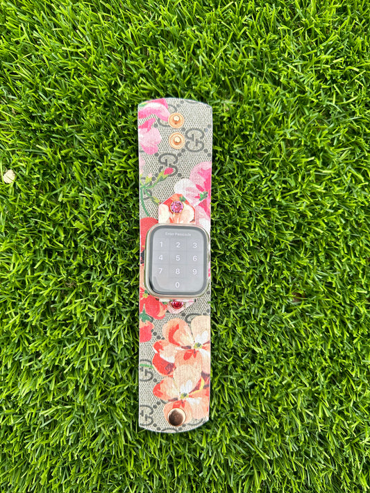 This is an authentic upcycled Pink Gucci Bloom. It is a canvas band material with the iconic GG monogram with pink flowers in the pattern. This is a single layer band with pink edge paint. The band is paired with a yellow gold rimmed rose crystal and rose gold hardware. 